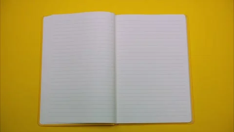 Opening a yellow notebook with blank pages for notes. Stop motion Stock Footage 325678394