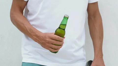 Opens a beer bottle with a beach slipper. Stock Footage 130823498