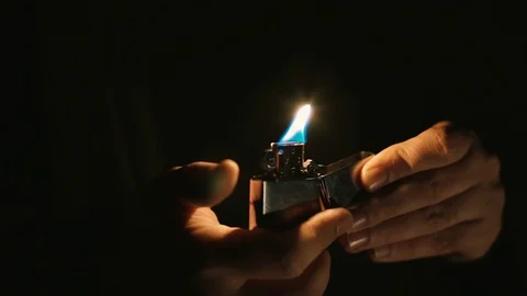 Opens a cigarette lighter and lights Stock Footage 129907009