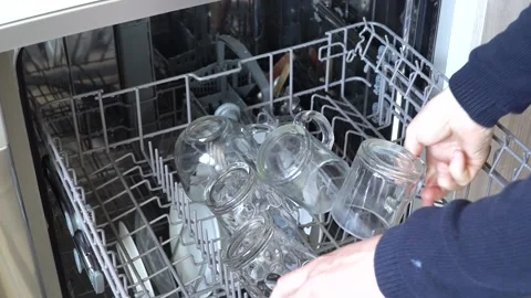 Opens the dishwasher and takes out clean dishes Stock Footage 149578346