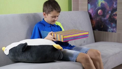 Opens the gift box. surprise and joy. a man in a dark T-shirt is sitting on the Stock Footage 167962072