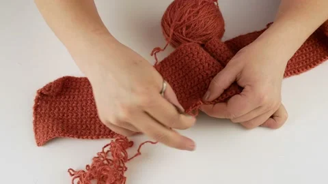 Opens the yarn and twists it into a ball.Female hands close-up on a white table. 스톡 동영상 141356694