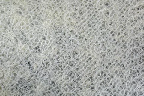Openwork background of knitted fabric made of white threads Stock Photos