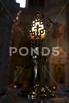 Openwork metal cross on the background of a large church chandelier Stock Photos