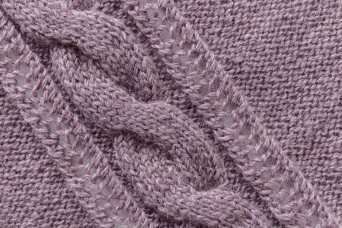 Openwork pattern knitted with needles from pink wool yarn. Stock Photos