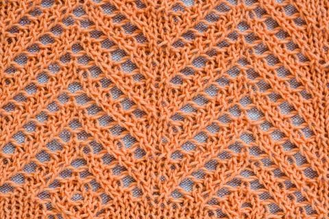 Openwork pattern with orange thread on a light background Stock Photos