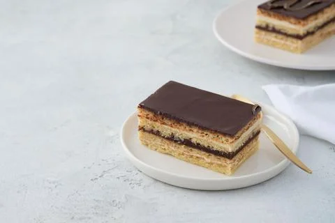 Opera cake is a type of almond sponge cake with a coffee and chocolate filling. Stock Photos
