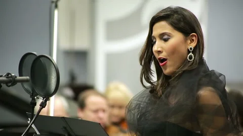 Opera singer sings in the microphone with the orchestra Stock Footage