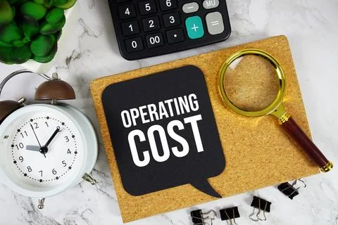 Operating Cost text on speech bubble with alarm clock, calculator and magni.. Stock Photos