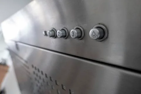 Operating elements of a silver extractor hood with light switch Stock Photos