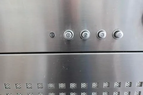 Operating elements of a silver extractor hood with light switch Stock Photos