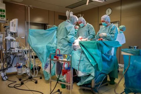 In  operating room, a caesarean section is performed by a surgical team Stock Photos