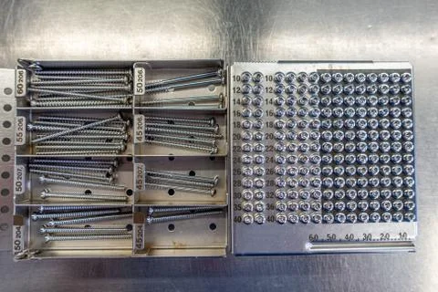 On  operating table is a tray with various surgical steel screws Stock Photos