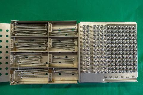 On  operating table is a tray with various surgical steel screws Stock Photos