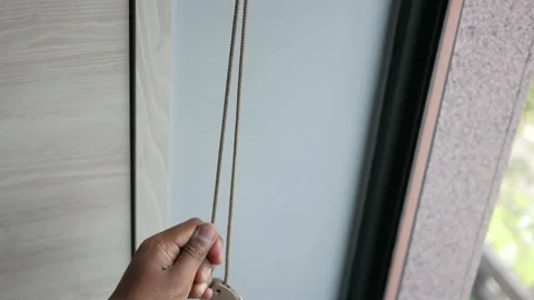 Operating window blinds with a simple pull motion Stock Footage 314090220