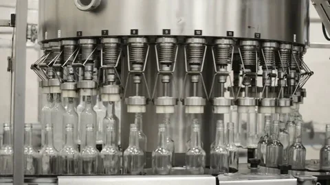 Operation of an automatic bottle filling machine with liquid. Movement, fixing Stock Footage 81402574