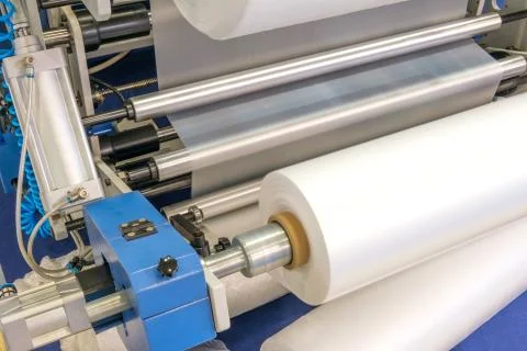 The operation of automatic plastic bag production machine. Close-up of the ro Stock-Fotos