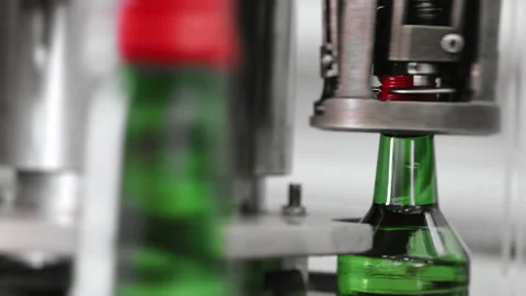 Operation of automatic screwing the cap on a glass green bottle. Stock Footage 284790928