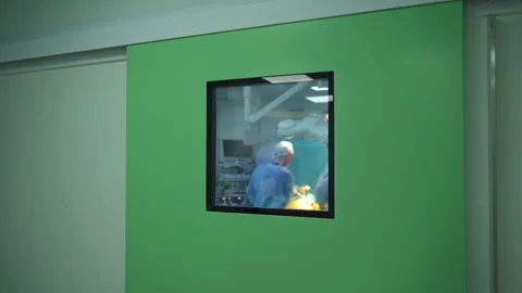 Operation in hospital. View through the window on surgical process Stock Footage 135399702