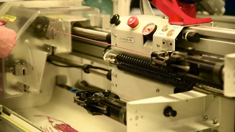 Operation of a thin wire rewinding machine at a factory producing electrica.. 動画素材 338385607