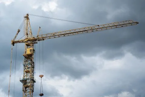 Operation of a tower crane during the construction of a multi-storey building Stock Photos