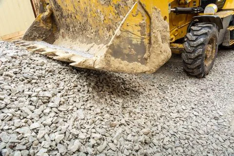 Operation of Wheel loader excavator for unloading crushed stone during Stock Photos