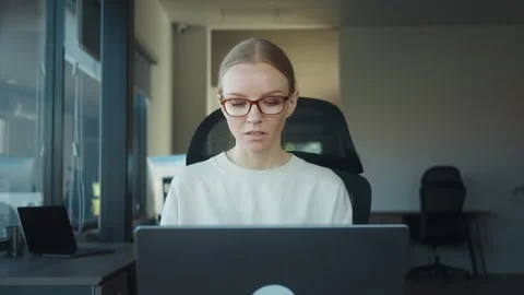Operations manager sitting at desk in modern office, working on laptop and Stock Footage 312120659