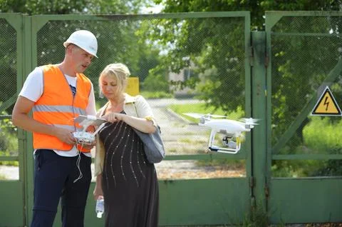 Operator adjusting industrial pro drone before launching it for checking powe Stock Photos