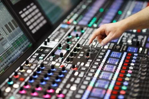 Operator adjusts controls of audio mixer panel Stock Photos