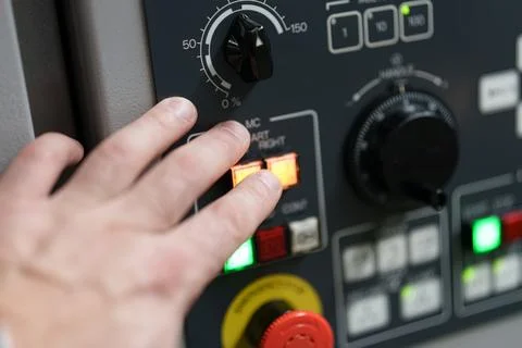 Operator adjusts settings on industrial machine control panel at factory du.. Stock Photos