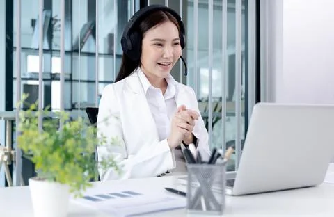 Operator agent with headsets working in a call center, Employee is chatting o Stock Photos