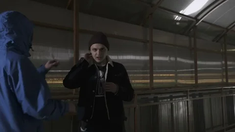 Operator approaches the rapper and corrects the earpiece in his ear Stock Footage