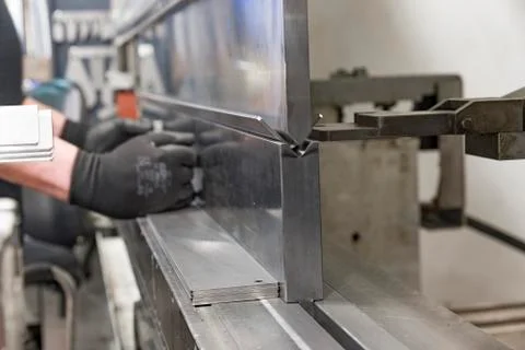 Operator bending metal sheet by sheet bending machine Stock Photos