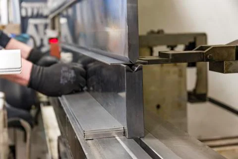 Operator bending metal sheet by sheet bending machine Stock Photos