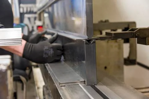 Operator bending metal sheet by sheet bending machine Stock Photos