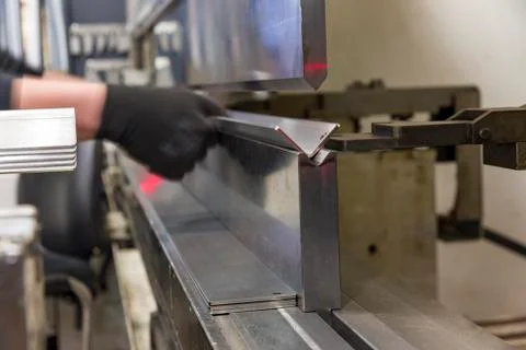 Operator bending metal sheet by sheet bending machine Stock Photos