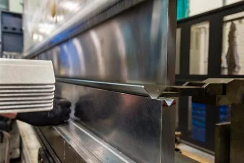 Operator bending metal sheet by sheet bending machine Stock Photos