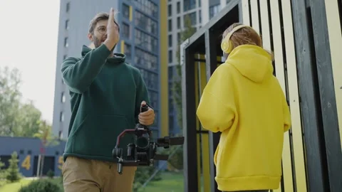 Operator with camera in his hands explains to dark-skinned model how to move in Stock Footage 244268443