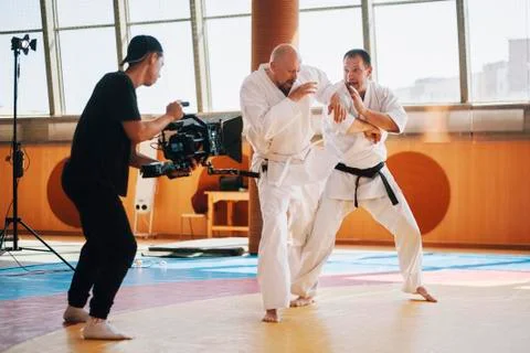 Operator with camera runs around fighters on sparing Stock Photos