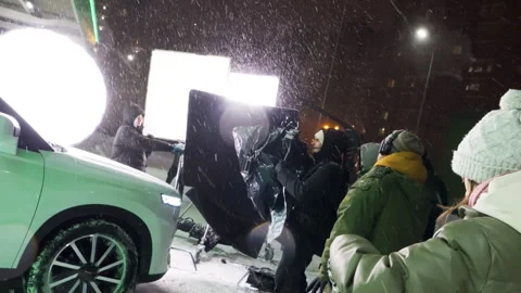 Operator clad in steadicam films actors entering sleek car Stock Footage 308941520
