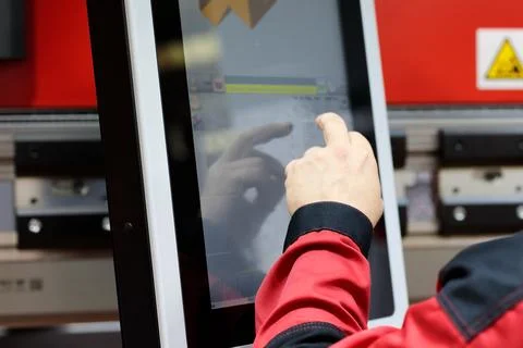 Operator of CNC press brake setting up the machine Stock Photos