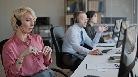 Operator Consulting Customer via Headset in Call Center, Working with Colleagues 스톡 동영상 335758958