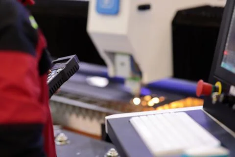 Operator controlling CNC laser cutting machine Stock Photos