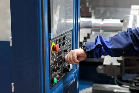Operator controls CNC lathe machining center Stock Photos