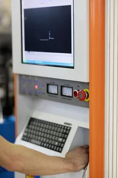 Operator controls CNC metal cutting machine Stock Photos