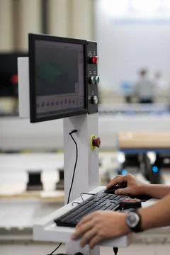 Operator controls computerized industrial machine Stock Photos