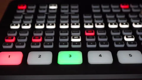 The operator controls the digital video console. There are many buttons on the Stock Footage 233296139