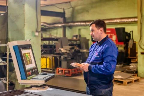 The operator controls a modern laser cutting machine. Laser cutting of sheet Stock Photos
