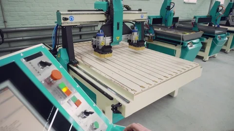 The operator controls the operation of the CNC machine. Stock Footage 126771317