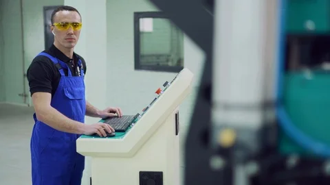 The operator controls the operation of the CNC machine. Video stock 127763009